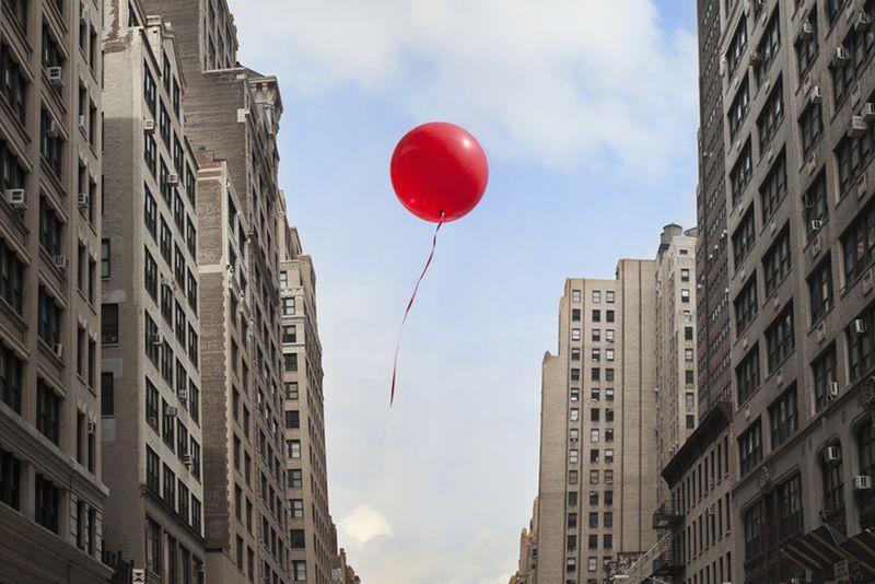 balon lecący między budynkami